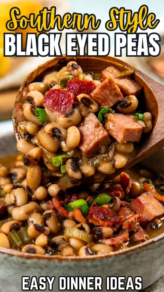 A wooden spoon holding a serving of Southern black eyed peas with ham topped with bacon and green onions.