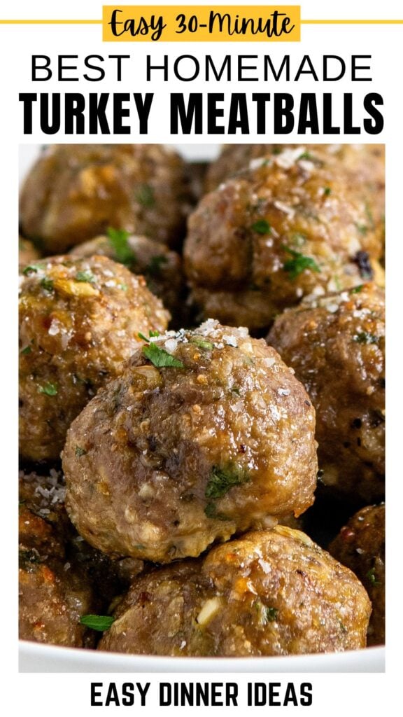 A close-up of several golden-brown ground turkey meatballs garnished with chopped herbs.