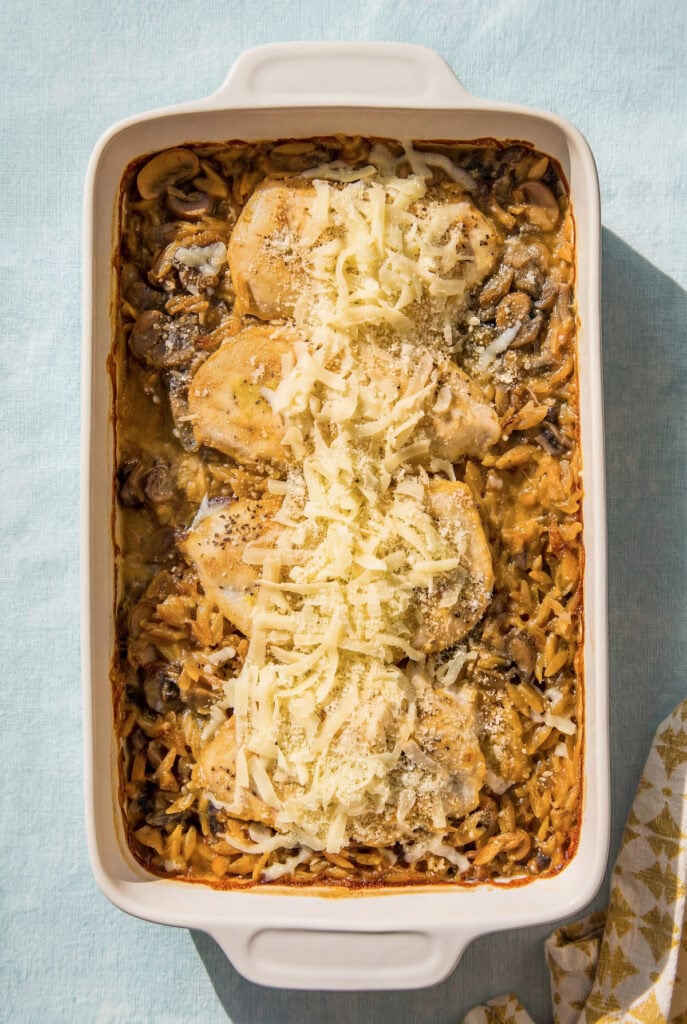 This dump-and-bake Chicken Orzo Bake is creamy and cheesy with serious flavor in every bite. One dish, simple ingredients, huge flavor! A baked orzo casserole dish filled with chicken, mushrooms, and a creamy sauce, topped with shredded cheese.