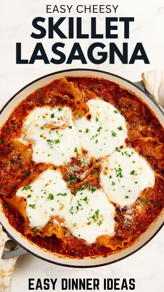 A skillet filled with lasagna topped with melted cheese and herbs, placed on a white surface. Text above reads Easy Cheesy Skillet Lasagna and below Easy Dinner Ideas.