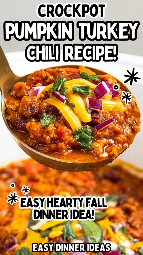 A spoonful of pumpkin turkey chili topped with shredded cheese, red onion, and herbs, held above a bowl.