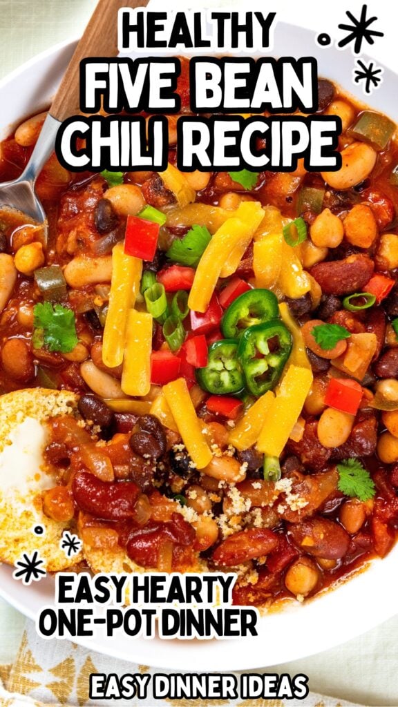 A bowl of 5 bean chili topped with cheese, peppers, and cilantro.